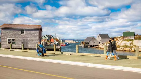 People walk on sidewalk at Peggy's Cove